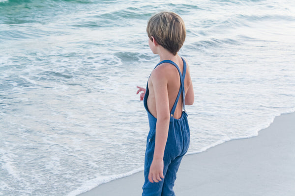 Watching the waves while wearing our super soft double gauze overalls in Ocean.