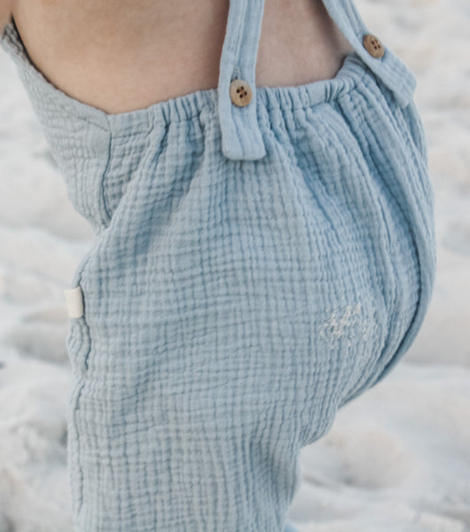 Playing in the sand while wearing our Super soft double gauze overalls in Seafoam.